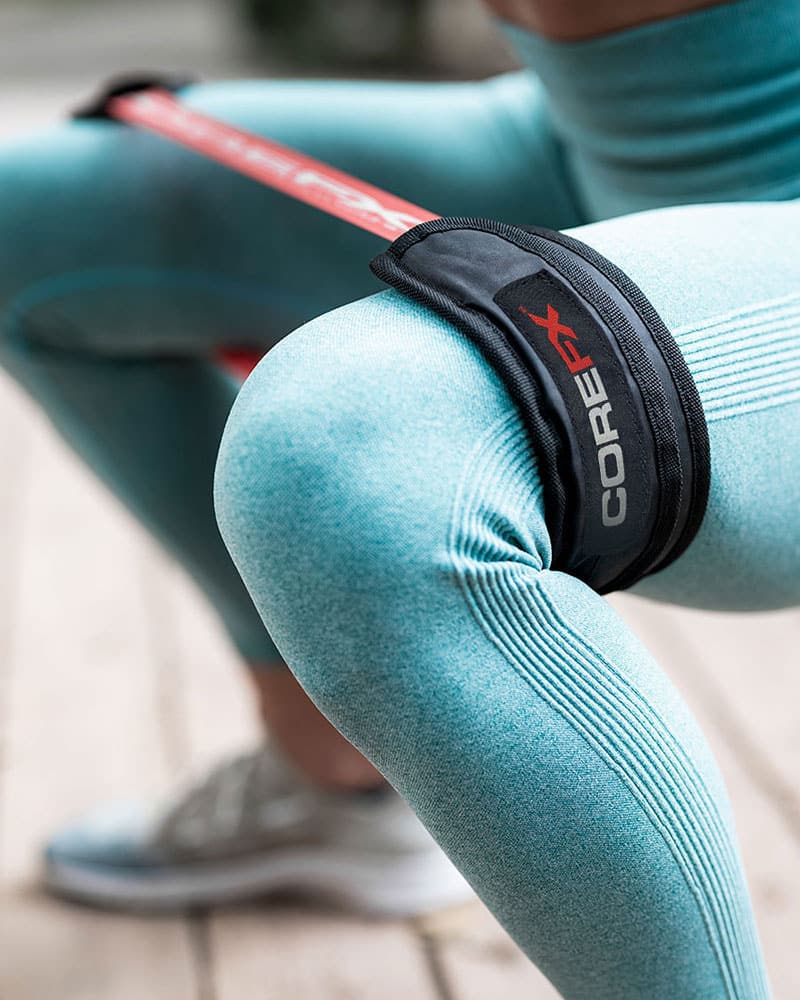 female athlete performing squats with the COREFX resistance loop sleeve