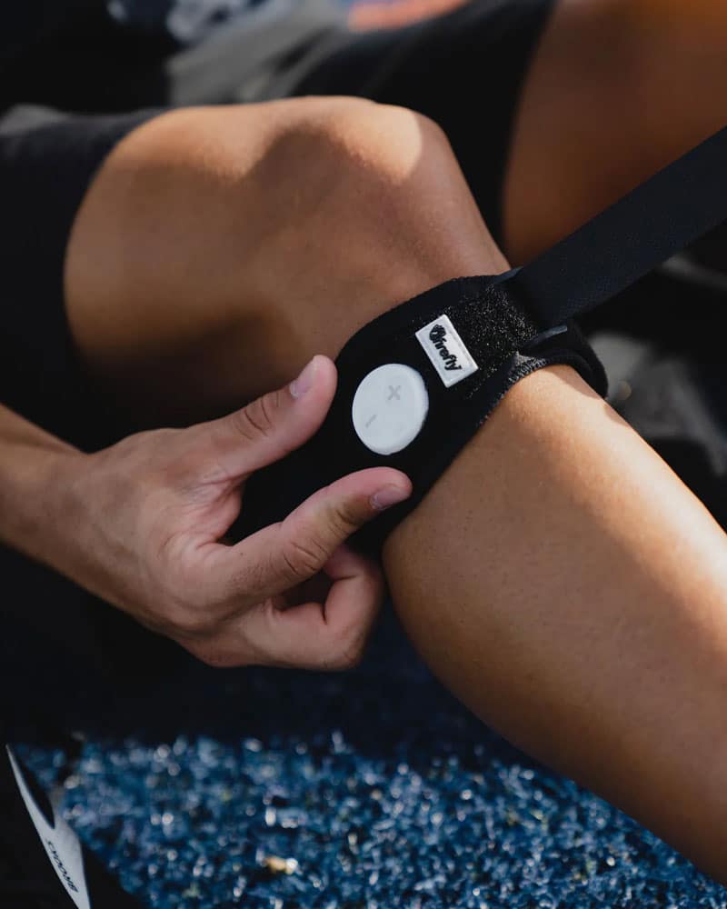 Placing firefly recovery knee strap on athlete