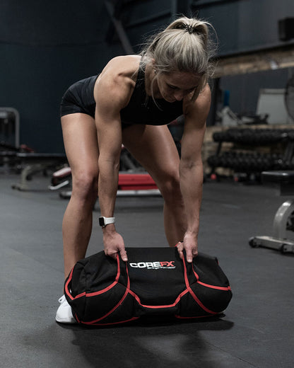 Female athlete lifting COREFX Workout Sandbag in gym
