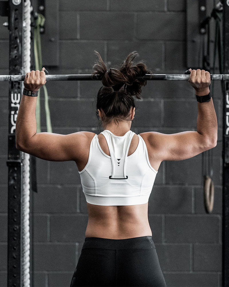 female lifting the concorde training barbell