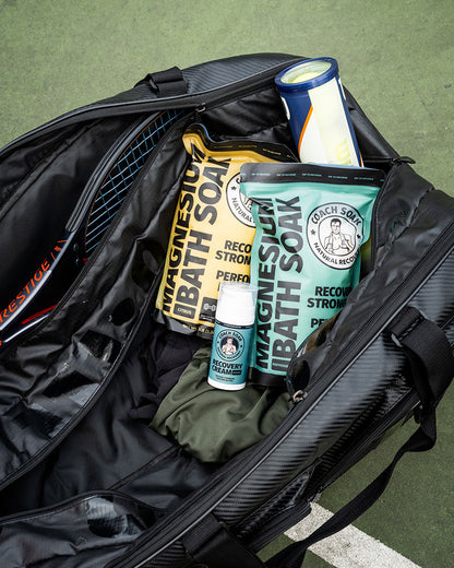 Tennis bag filled with Coach Soak recovery cream and bath soak for muscle recovery