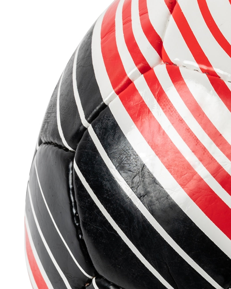 Close-up of red and black stripes on Match soccer ball