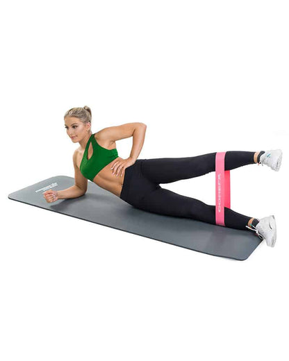 Woman working out with exercise mat and fitness loop