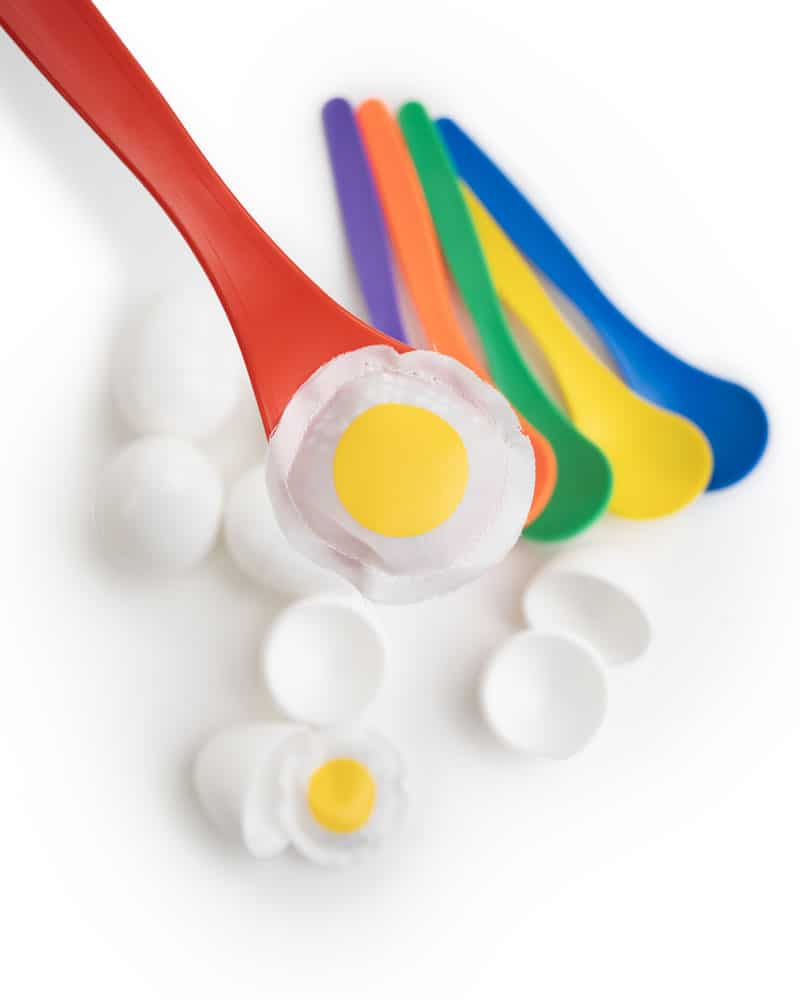 Red spoon with the inside portion of the plastic egg from the spoon and egg game
