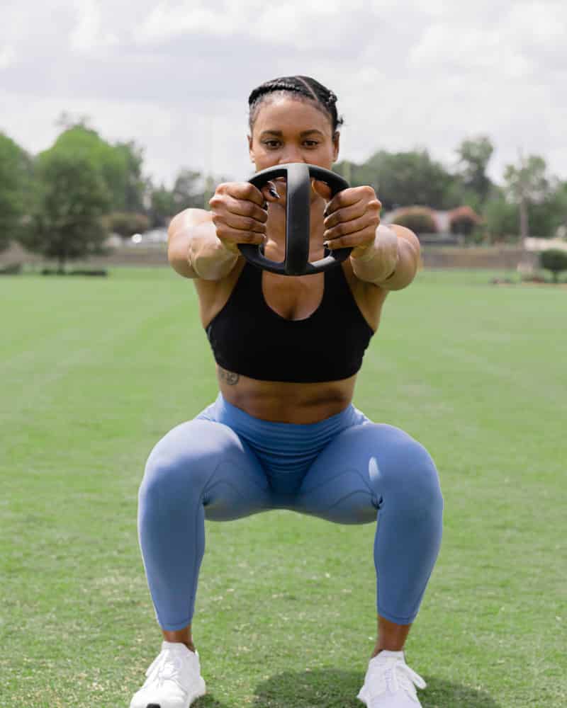 Woman using YBell Arc for squat workout