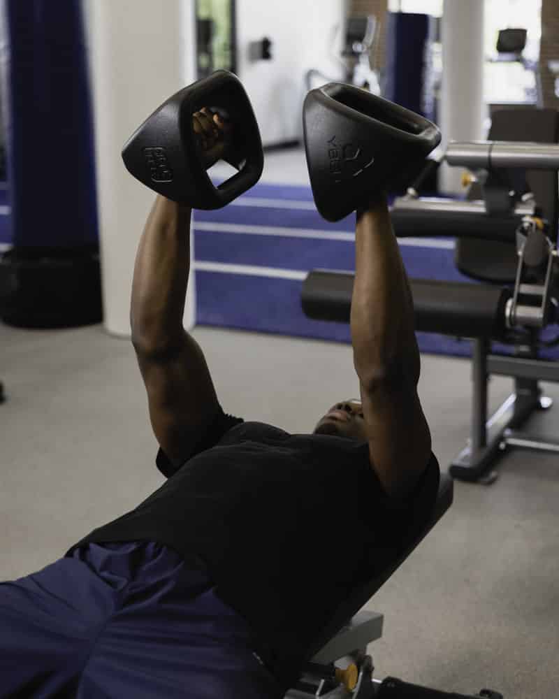 Male doing dumbbell exercises with YBell Pro
