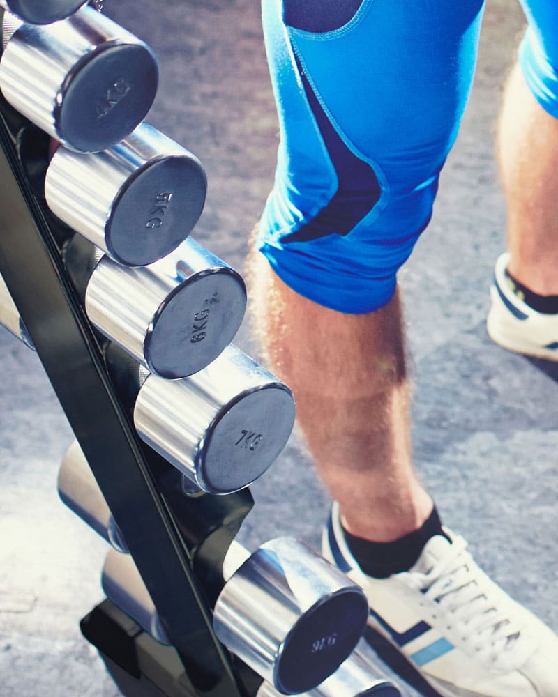 Male athlete grabbing dumbbell from York 2 Sided A Frame Rack
