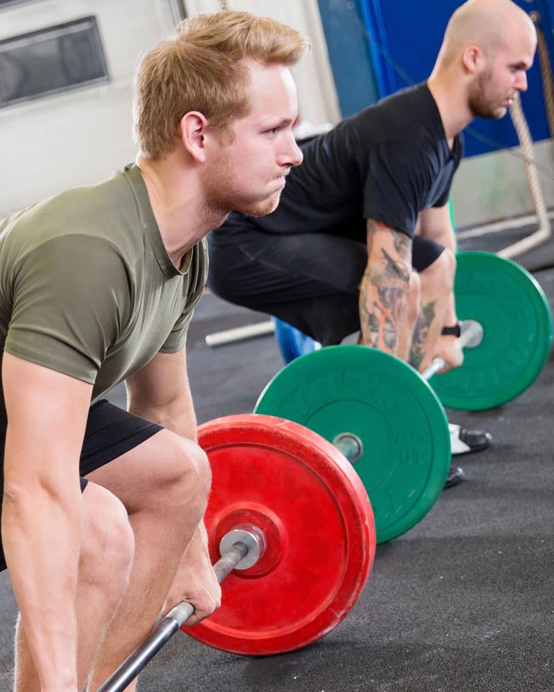Male athletes with coloured rubber bumper plates by York Barbell