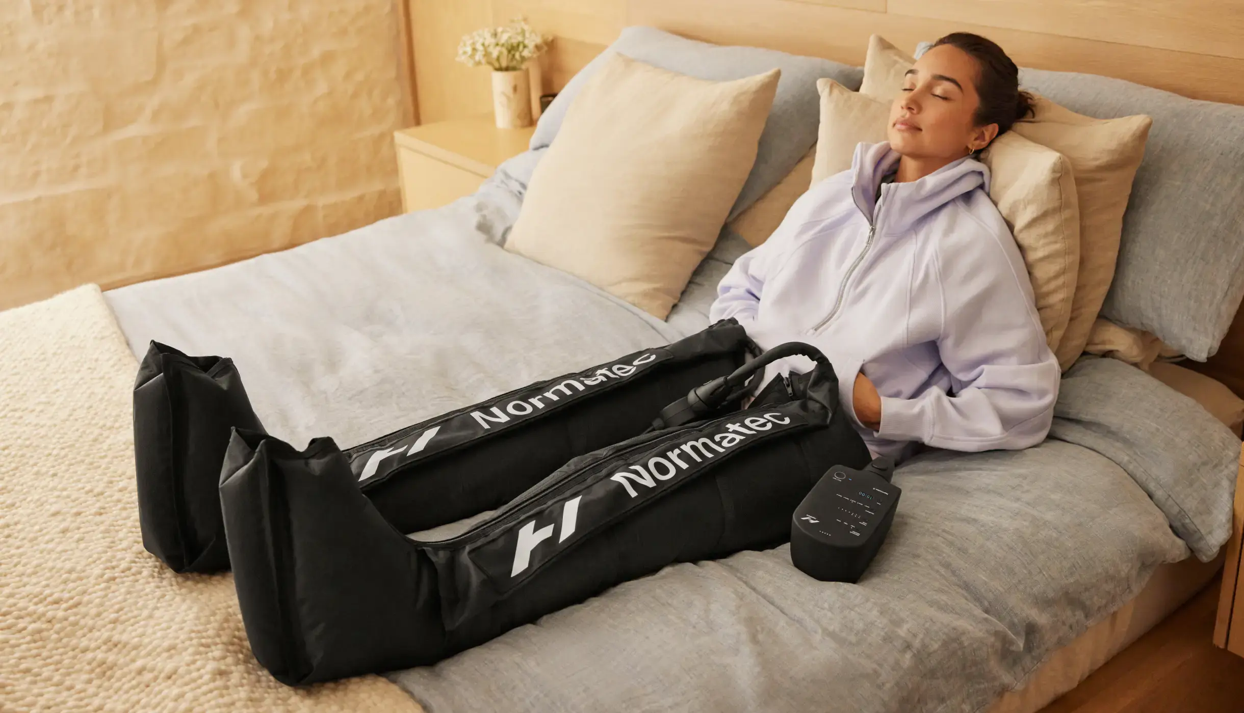 Woman recovering with Normatec in bed